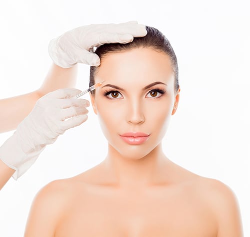 Plastic Surgeon Making Botox Injection In Woman’s Eyebrow