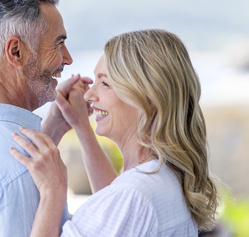 Mature couple dancing at a home or holiday villa.