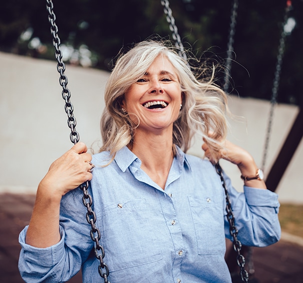 Portrait of mature woman with gray hair sitting on swing