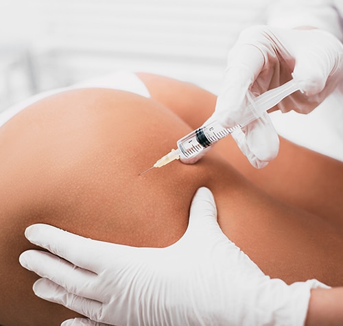 Beautician doing Injection into female buttocks close-up